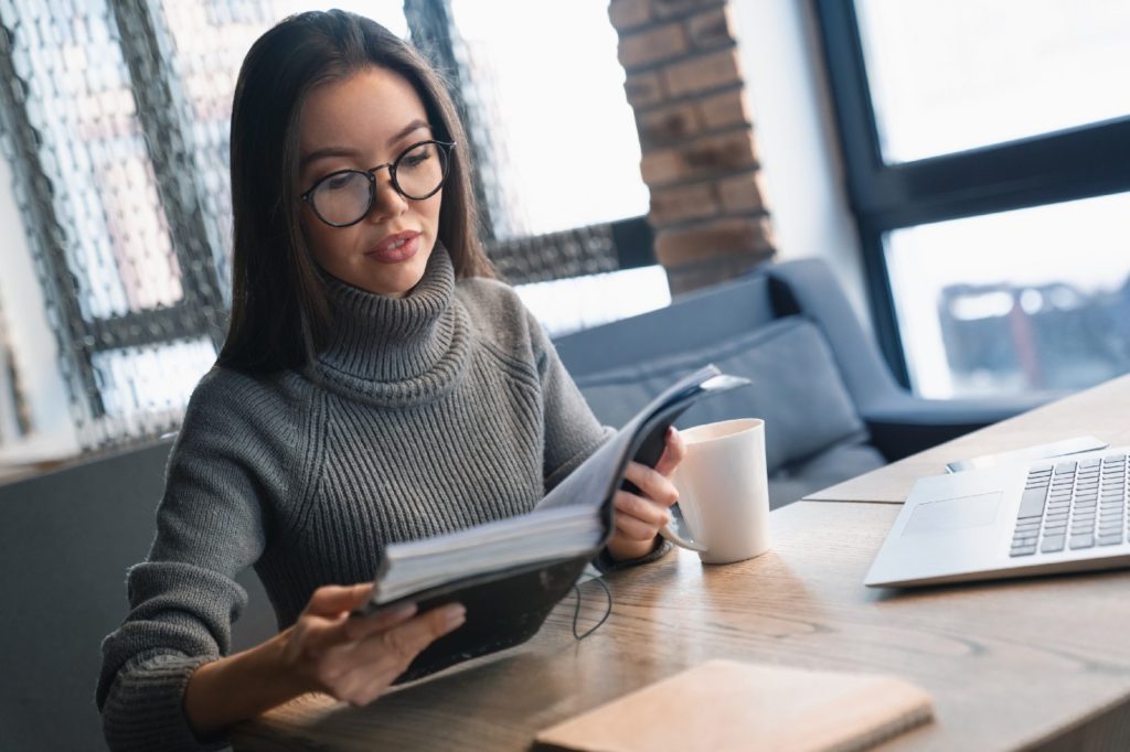 woman reading a book at a cafe