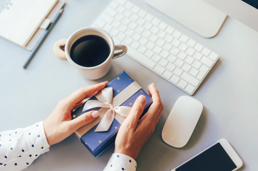 top view of work office space, woman holding gift box