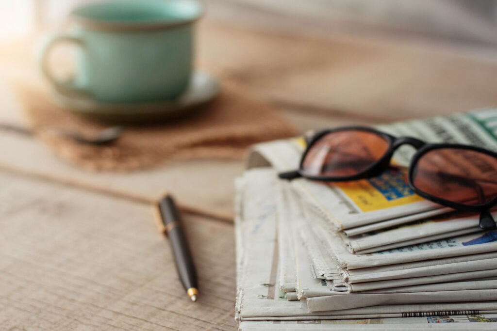 newspapers on the desk with glasses, press release writing, press release distribution, press release writer, press releases