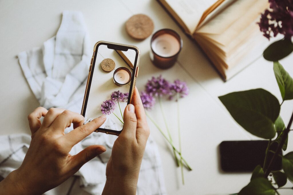 social media exper taking a photo of candles and purple flowers