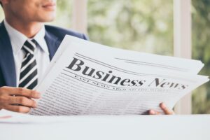 Asian Businessman is sitting and reading news from a newspaper at the office.