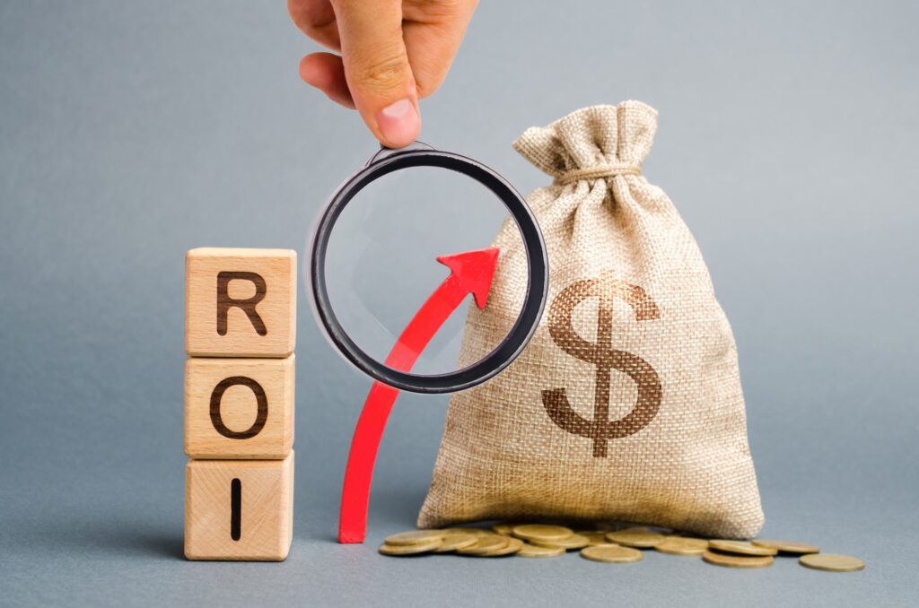 Wooden blocks with the word ROI and the up arrow with the money bag, what is organic traffic, how to leverage organic traffic, how to get organic traffic