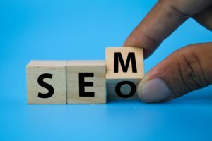 wooden cube with the letters SEM or SEO.