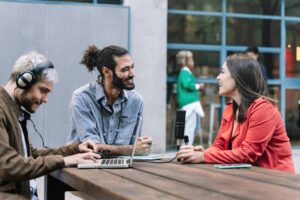 Young journalist content creator recording informal conversation interview with trendy woman