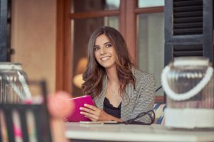 Content woman writing in notepad on terrace